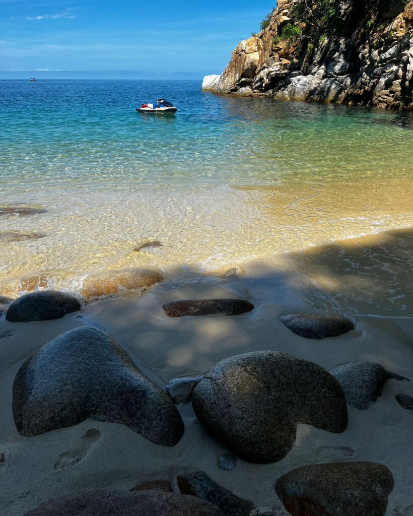 Secluded beach cove with crystal clear water and rocky shoreline in Puerto Vallarta