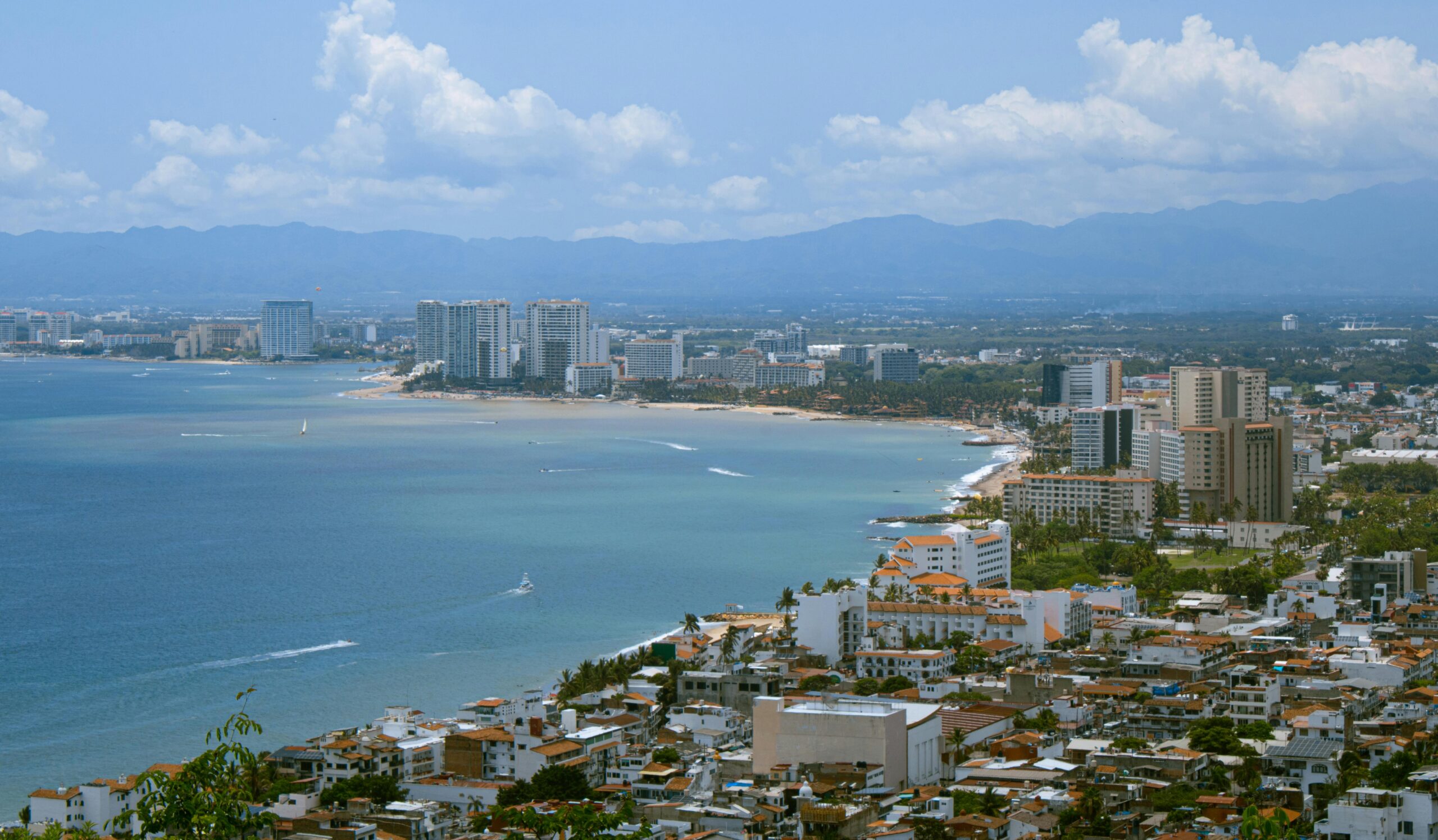 Aerial view of Puerto Vallarta coastline and 5 de Diciembre neighborhood with ocean and high-rise buildings