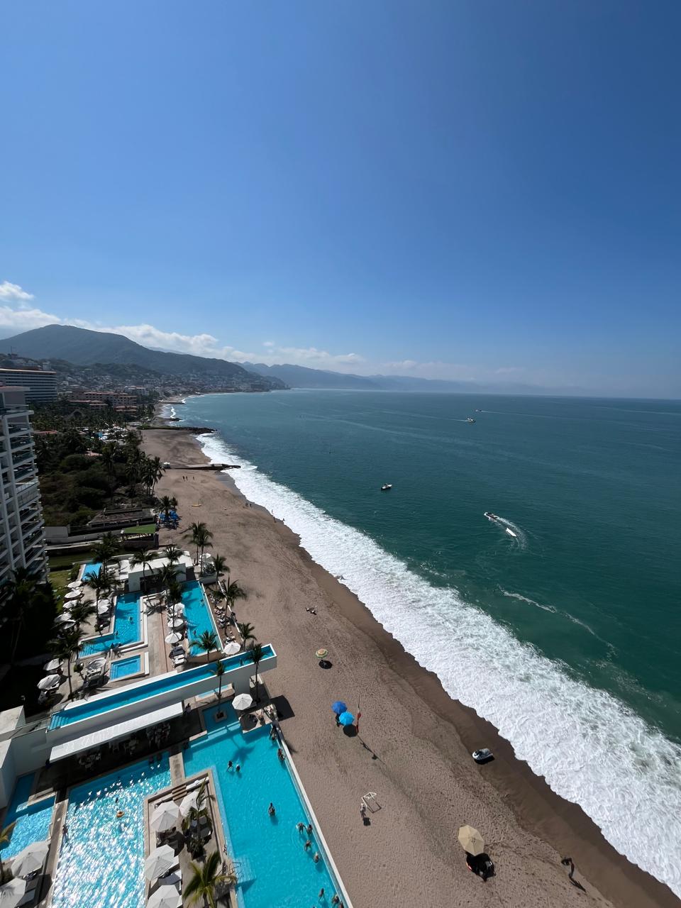 Luxury beachfront real estate with ocean view, resort pools, and coastline showing how the sea increases property value