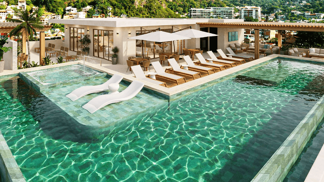 Luxury rooftop infinity pool with lounge area overlooking Puerto Vallarta and the Sierra Madre mountains.