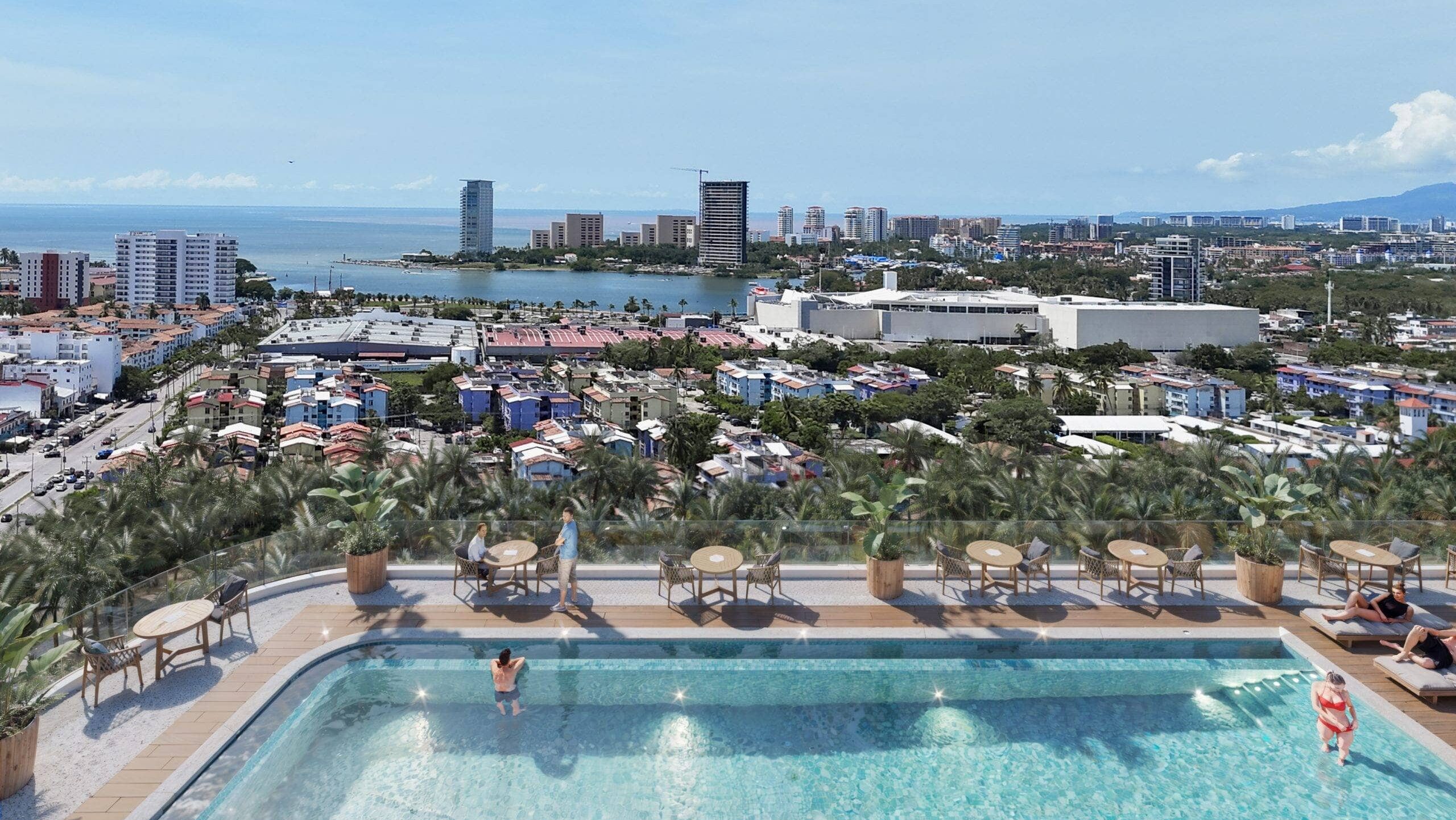 Luxury rooftop infinity pool with panoramic city and ocean views in a modern Puerto Vallarta condominium.