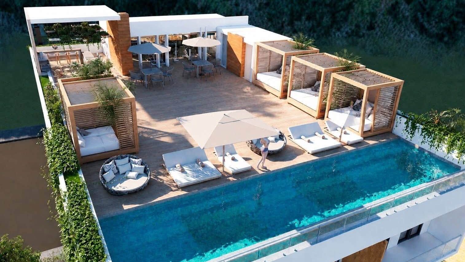 Luxury rooftop infinity pool with lounge areas and panoramic views in a Puerto Vallarta condominium.
