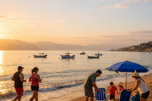 Families enjoying a peaceful sunset on a Puerto Vallarta beach with fishing boats on Banderas Bay.