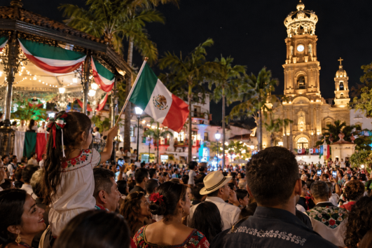 Mexican Independence in Puerto Vallarta celebration with crowds, Mexican flags, and illuminated downtown church