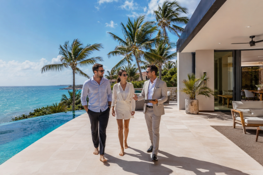 Luxury beachfront property tour in Mexico with a real estate agent showing an oceanfront villa to international buyers.