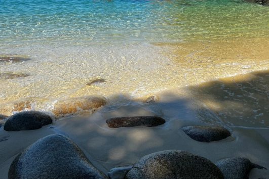Secluded beach cove with crystal clear water and rocky shoreline in Puerto Vallarta