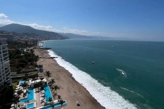Luxury beachfront real estate with ocean view, resort pools, and coastline showing how the sea increases property value