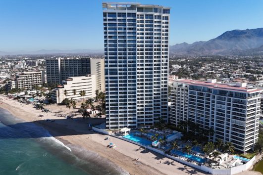 A stunning beachfront property in Puerto Vallarta with an unobstructed ocean view, showcasing a luxurious home with direct beach access