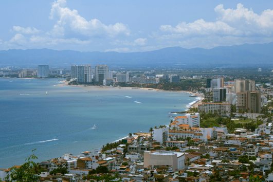 Aerial view of Puerto Vallarta coastline and 5 de Diciembre neighborhood with ocean and high-rise buildings