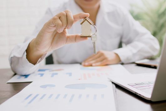 “Businessman holding a key over financial charts, symbolizing a real estate investment in Puerto Vallarta.”